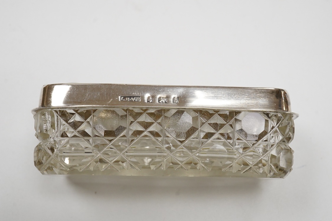 A George III engraved silver helmet shaped cream jug, Henry Chawner, London 1788(repair), height 15.3cm, together with two George V silver toast racks, a silver mounted glass toilet jar and a modern silver mounted bottle